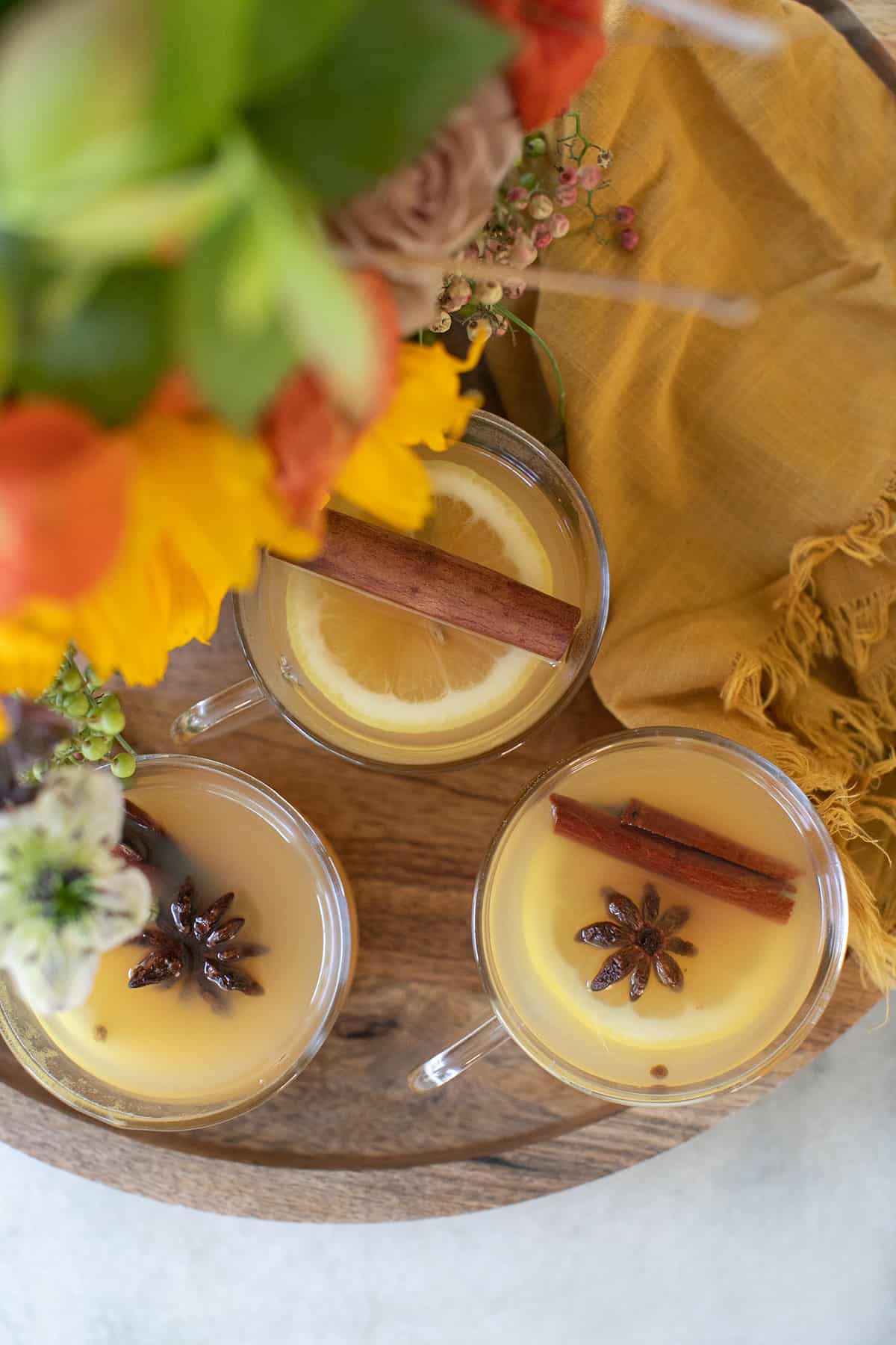 mulled apple cider on a wooden tray with sunflowers