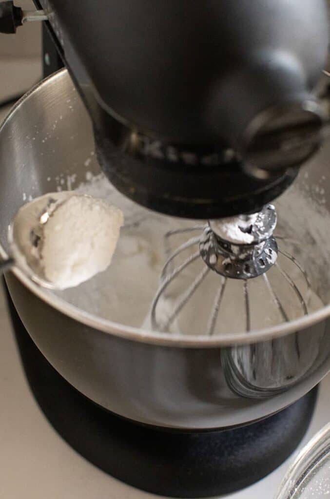 Adding powder sugar into a mixing bowl to make icing.