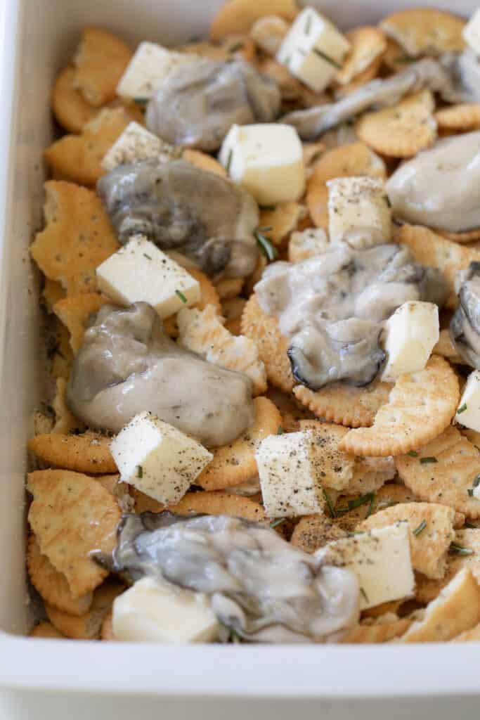 Layering oysters and crackers for oyster stuffing.
