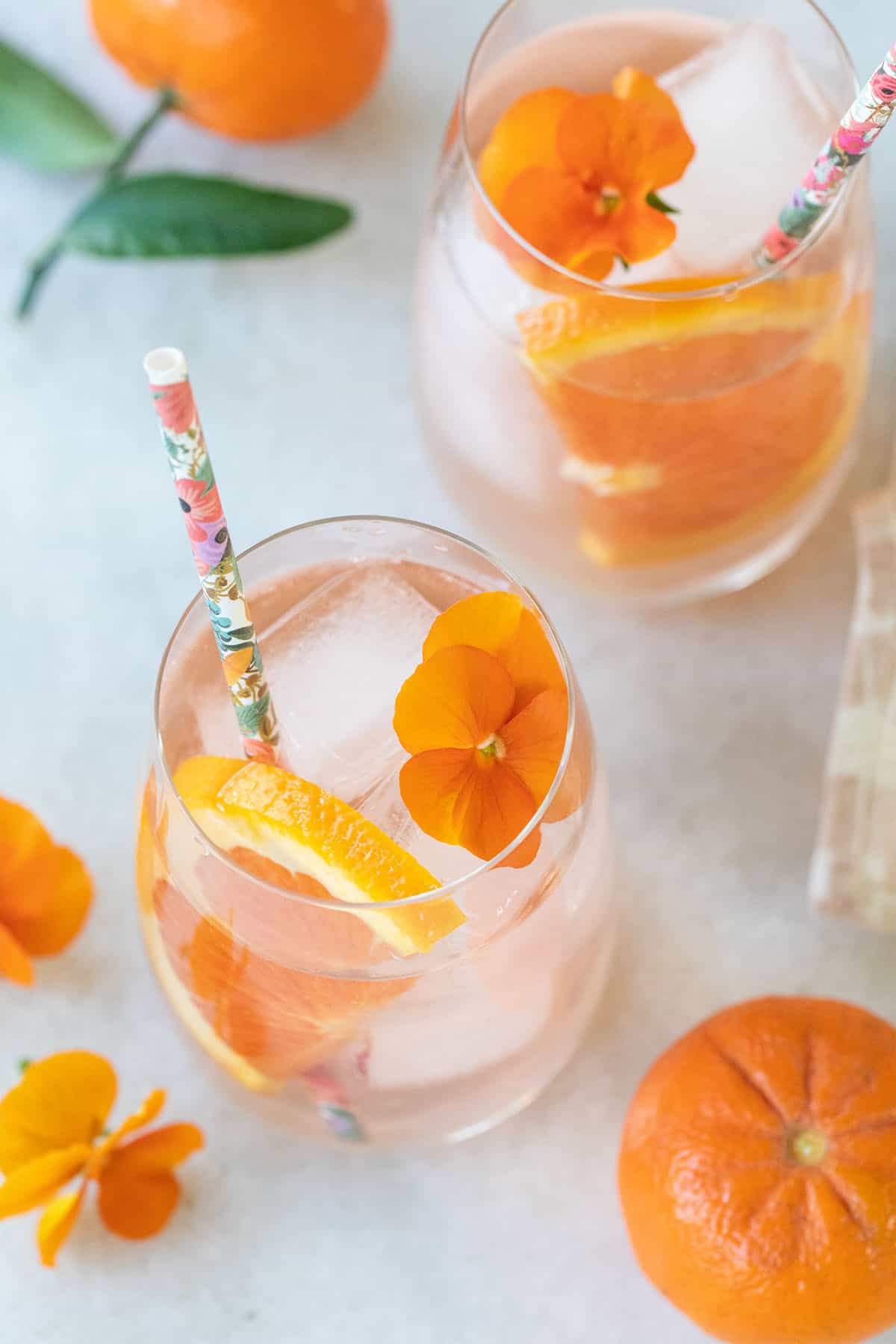 light pink cocktail with orange flower and slice