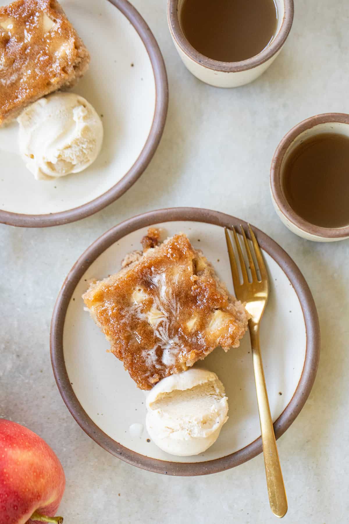 apple cake on a plate with a scoop of vanilla ice cream. 