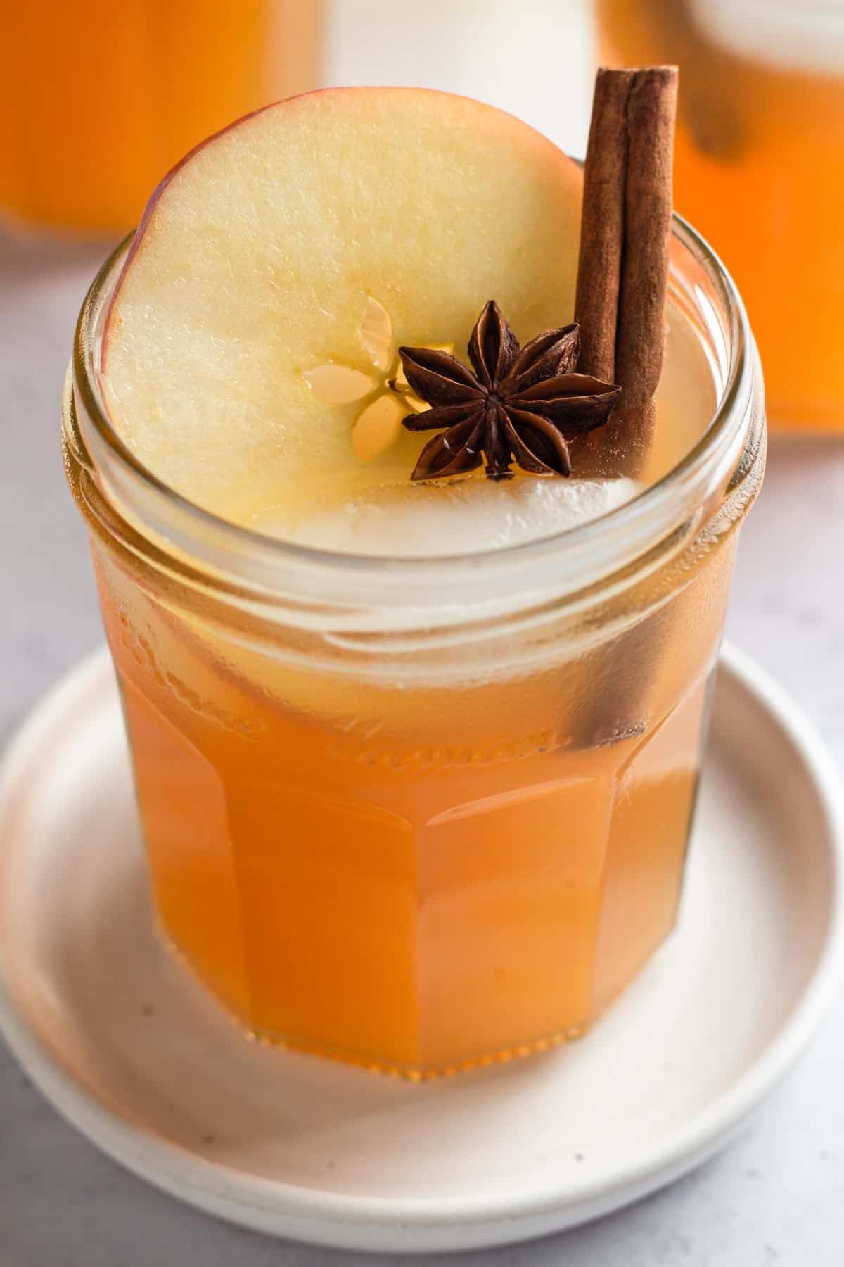 pineapple apple cider cocktail with cinnamon stick.