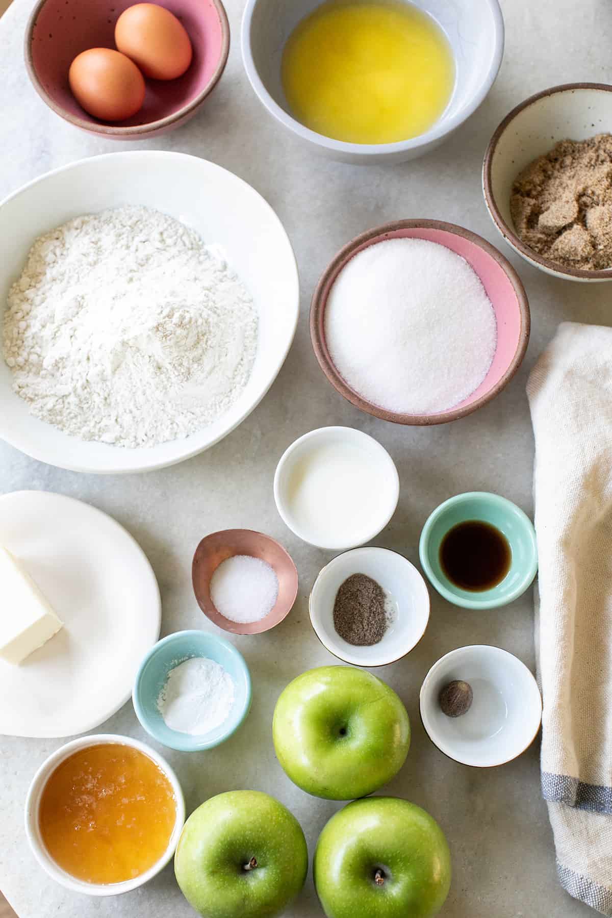 Ingredients in bowls to make an apple cake.