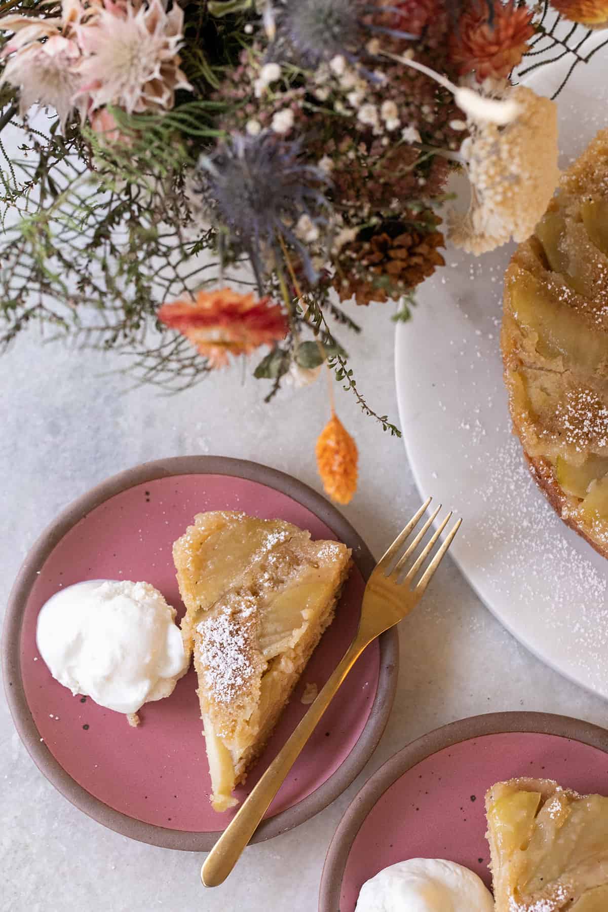 Slice of an apple upside cake cake on a plate.