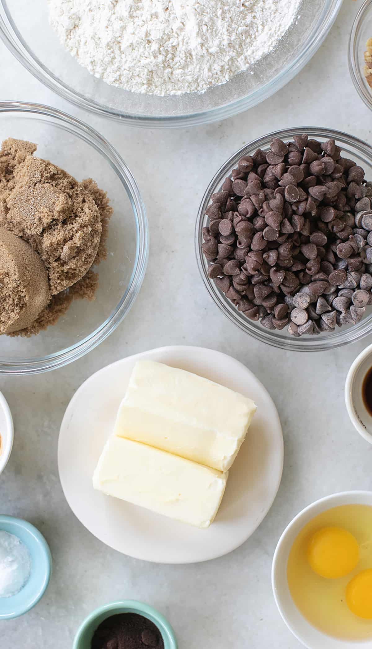 Butter, chocolate chips, brown sugar, flour, eggs in a bowl.