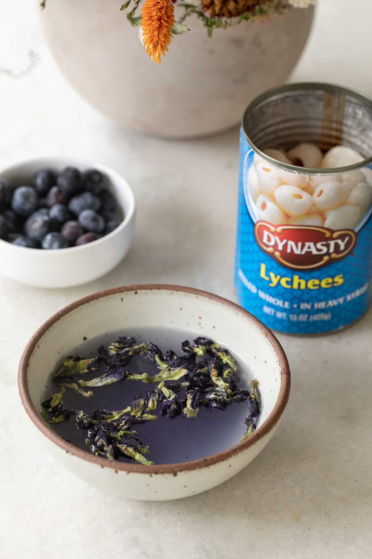 purple vodka, canned lychee and blueberries in bowls. 