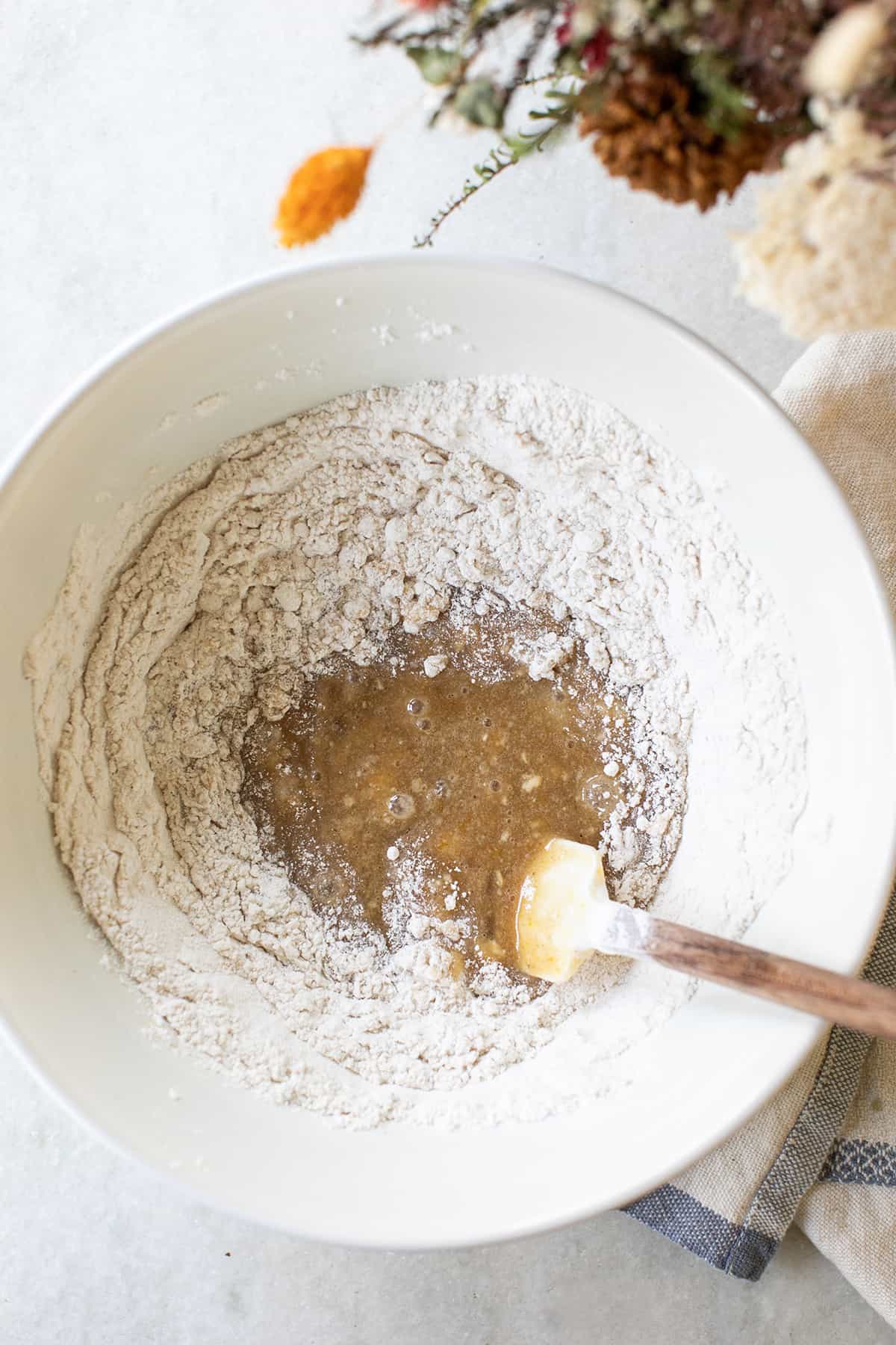 Flour and apple batter in a mixing bowl. 