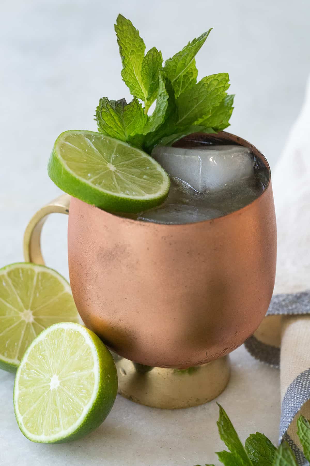 Bourbon mule in a copper mug with lime wheels.