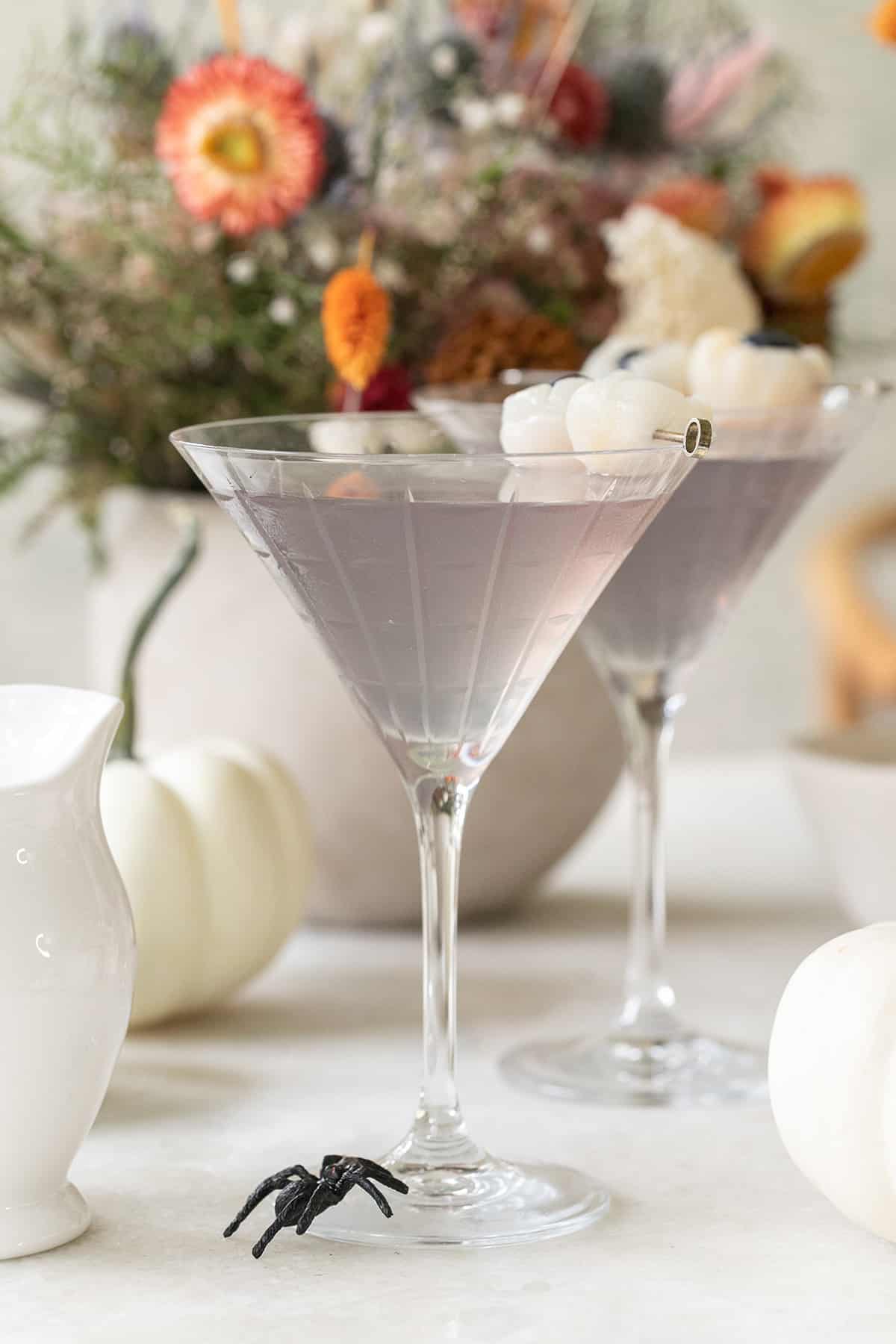 Lychee martini recipe with butterfly pea flowers to make it light purple.