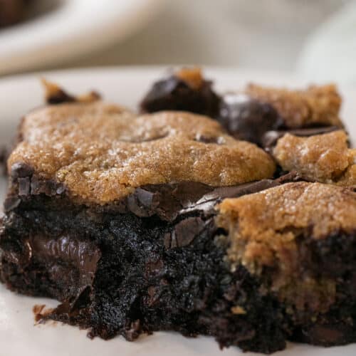 A gooey, chocolate broke on a plate with a bite taken out of it.