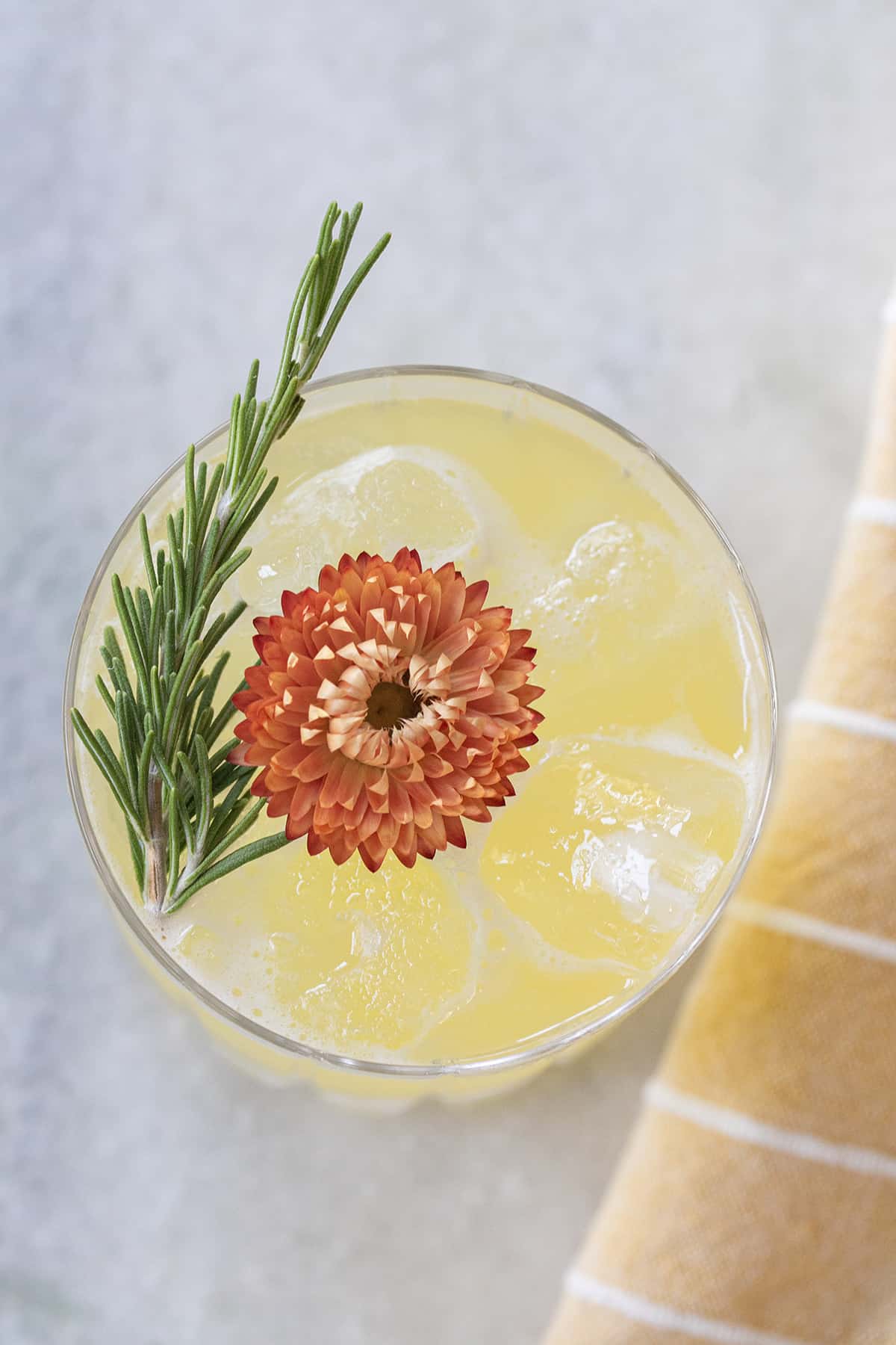 A cocktail with pineapple juice garnished with a flower.