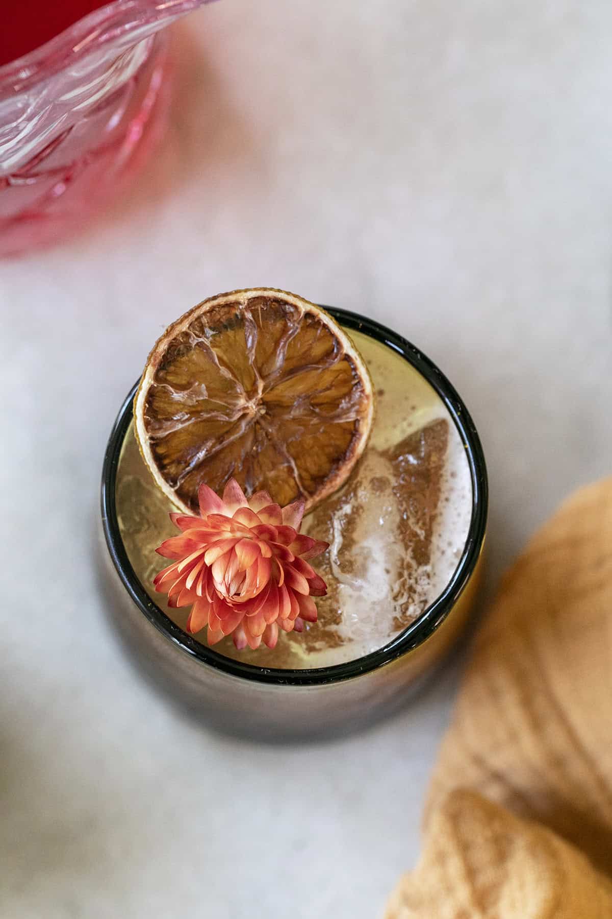 Thanksgiving cocktail in a glass with lime and a flower.