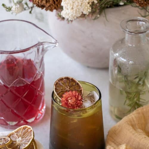 Thanksgiving mocktail in a green glass with cranberry juice and flowers.