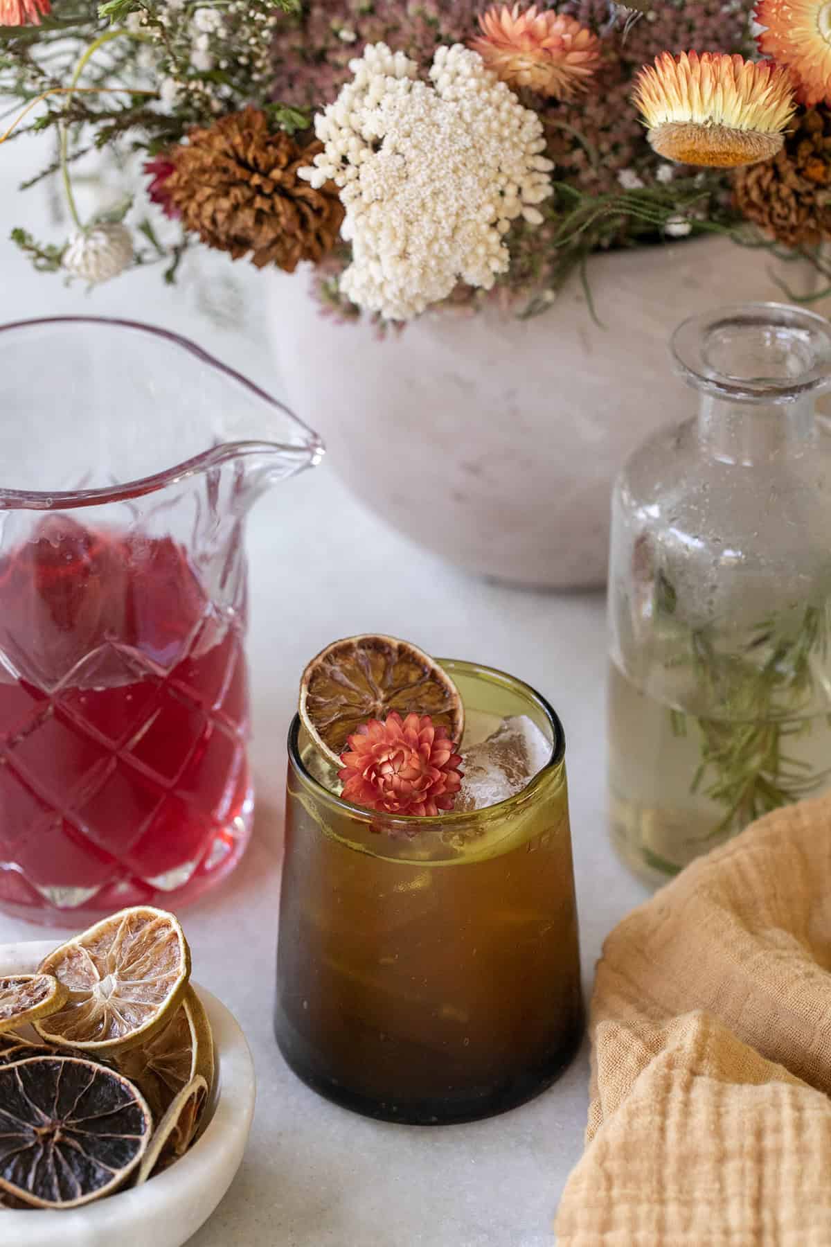 Thanksgiving mocktail in a green glass with cranberry juice and flowers.