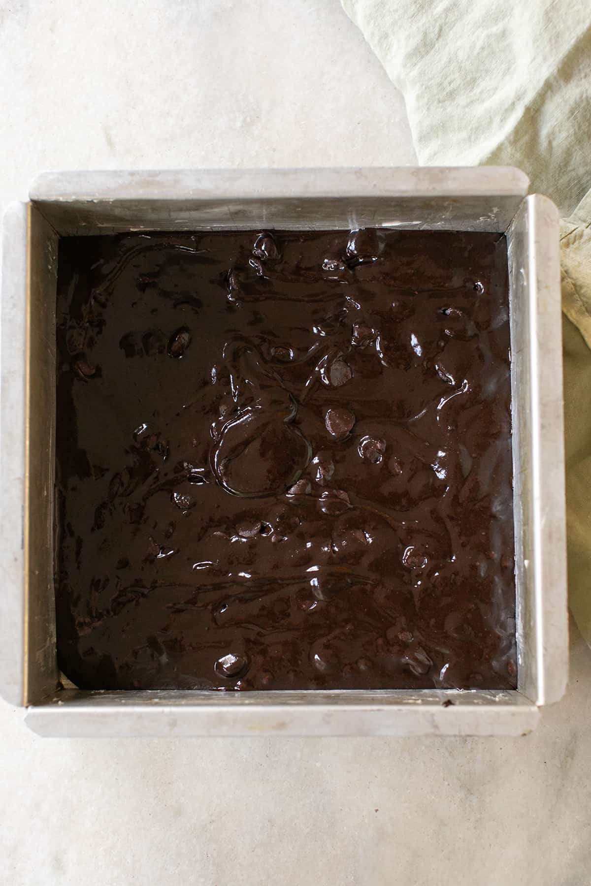 9x9 metal baking pan with brownie batter in it.