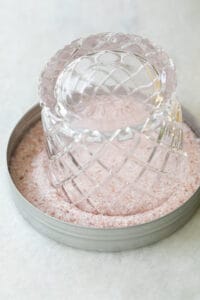A margarita glass dipped upside down in pink salt.