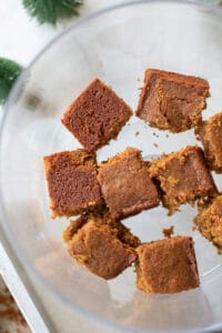 The bottom of a trifle dish with cubes of fluffy gingerbread cake.
