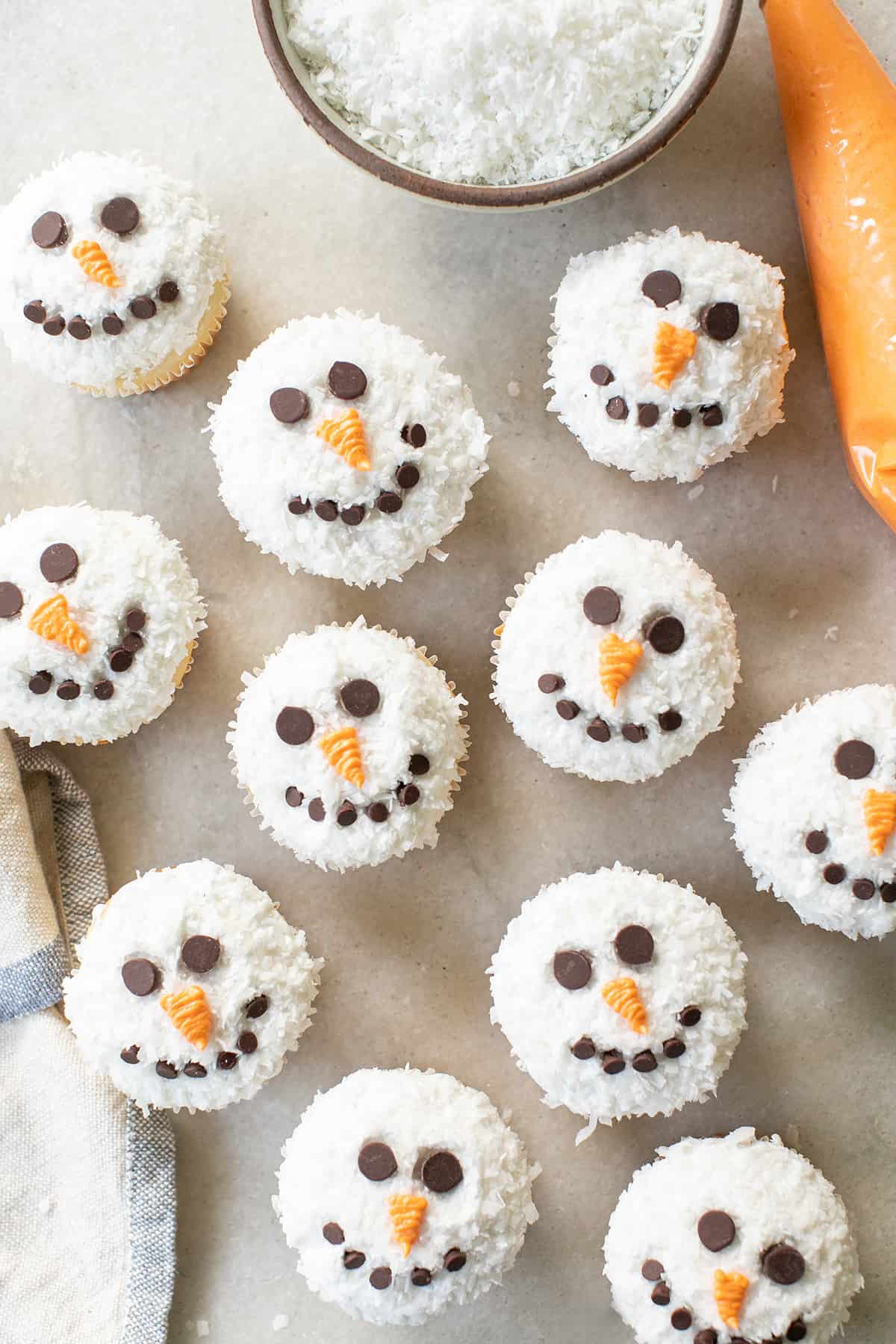 snowman cupcakes on a marble table.