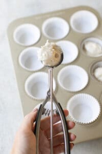 using a cookie scooper to scoop cake batter.