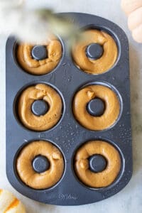 Pumpkin donuts in a donut pan.