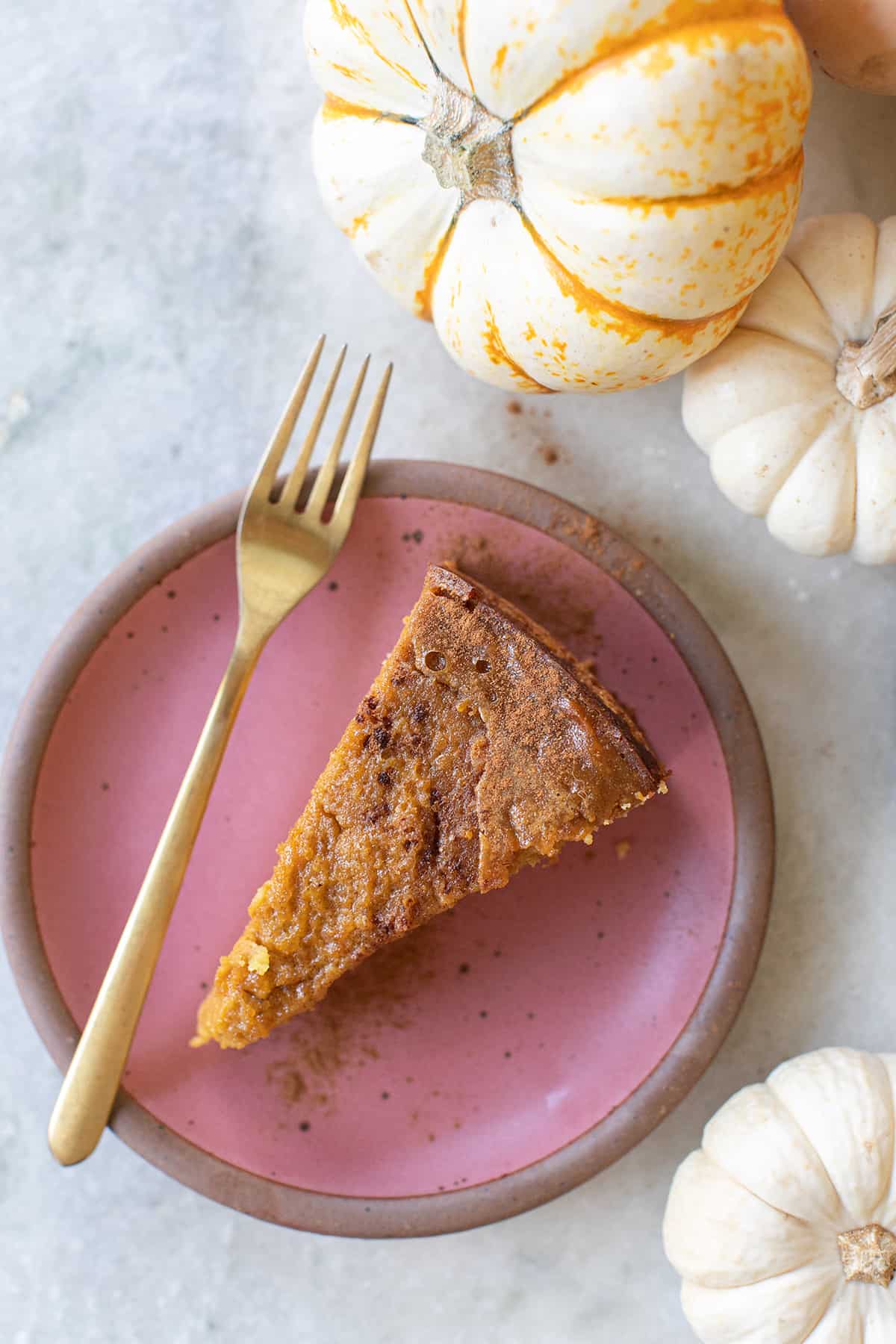Slice of a pumpkin cake on a pink plate.