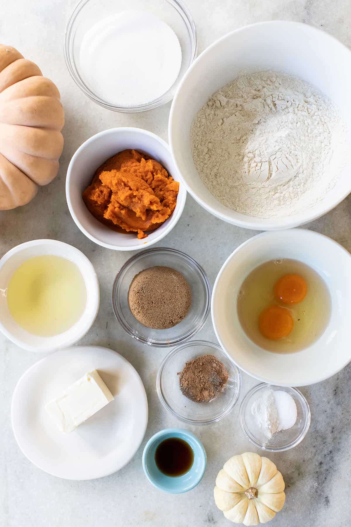 Ingredients in mixing bowls to make baked pumpkin donuts.