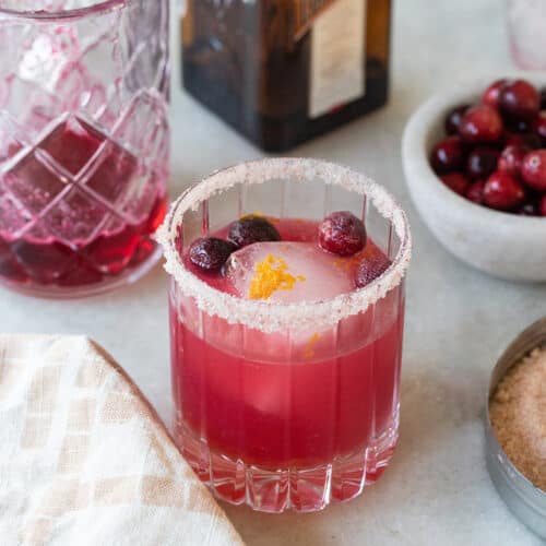 Cranberry margarita with a pink vibrant color and a salted rim.