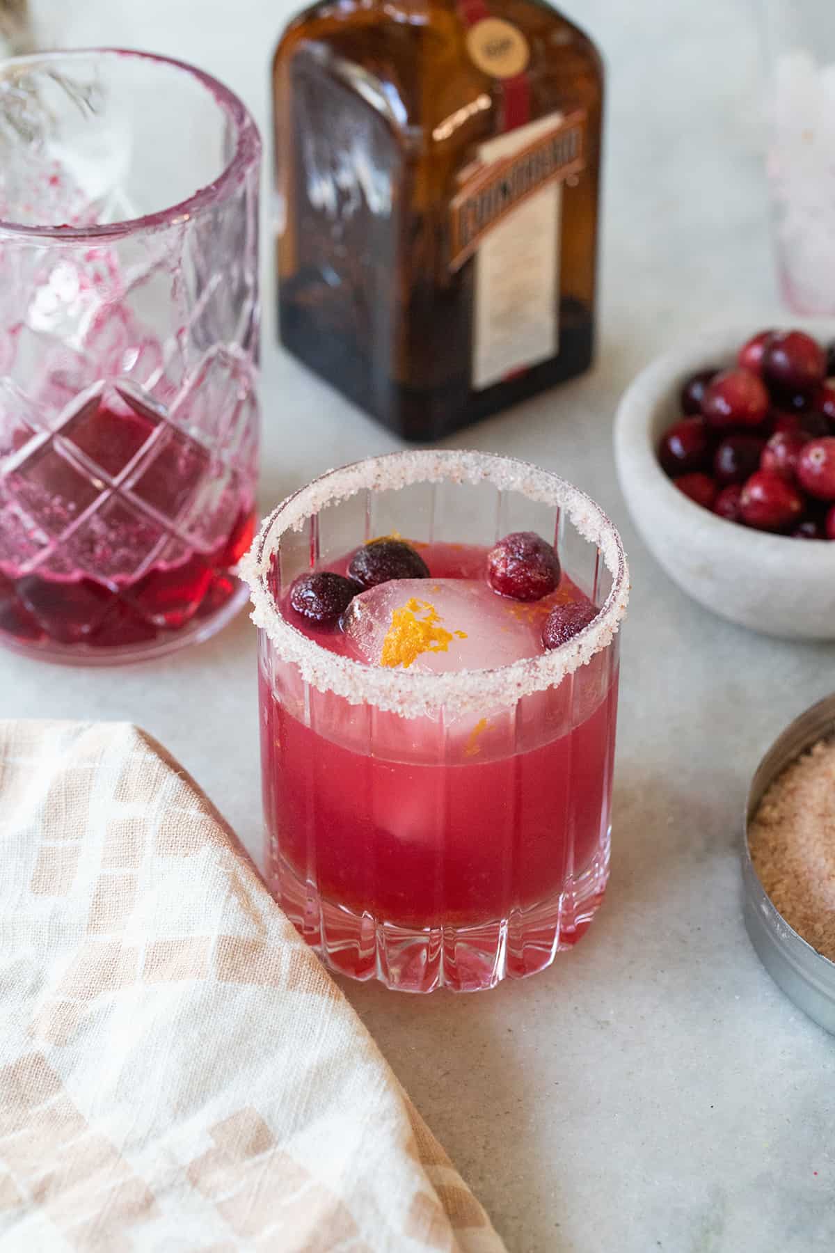 Cranberry margarita with a pink vibrant color and a salted rim.