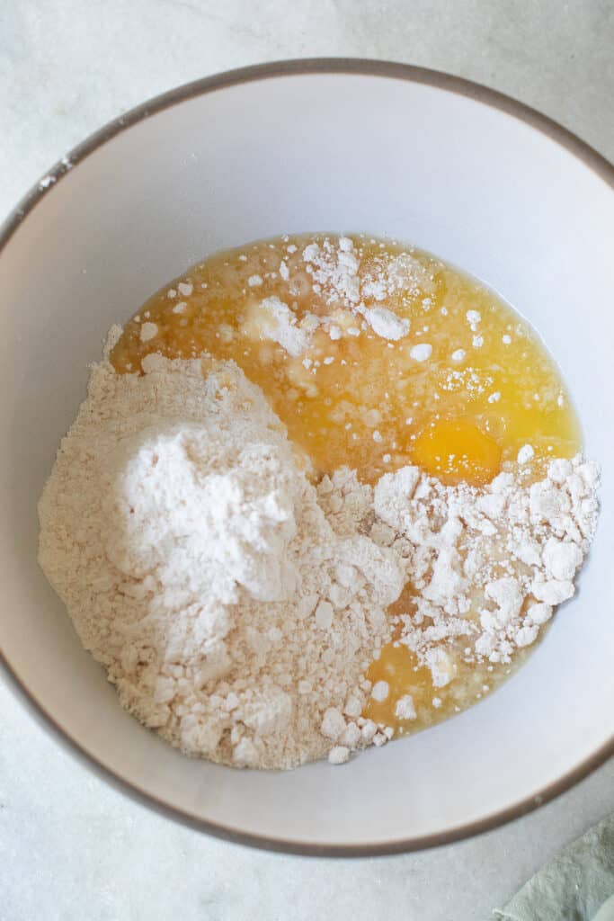Butter, eggs and cake batter in a bowl to make a gooey butter cake.