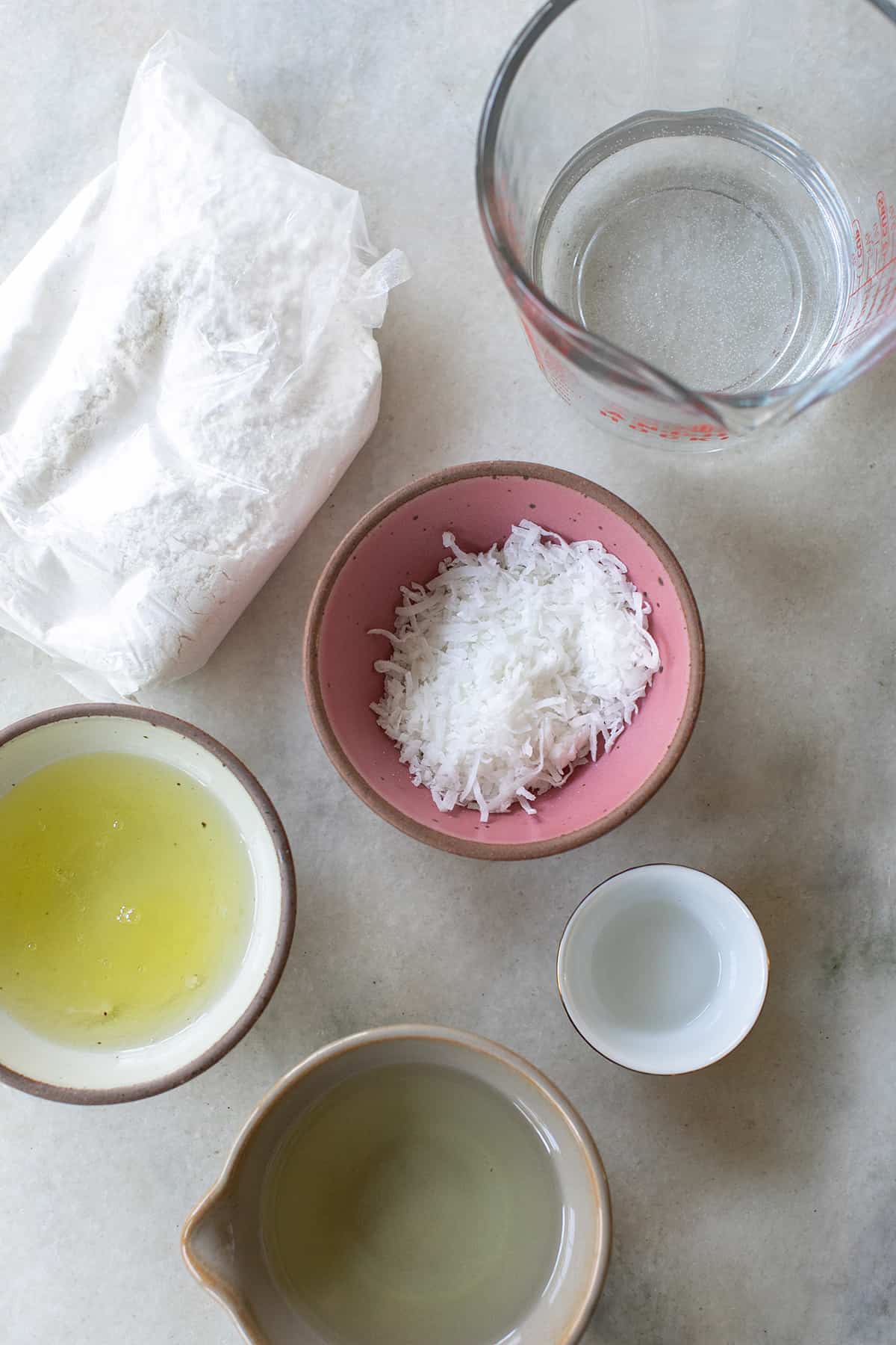 Cake mix, oil, eggs, coconut in small bowls to make coconut cupcakes.