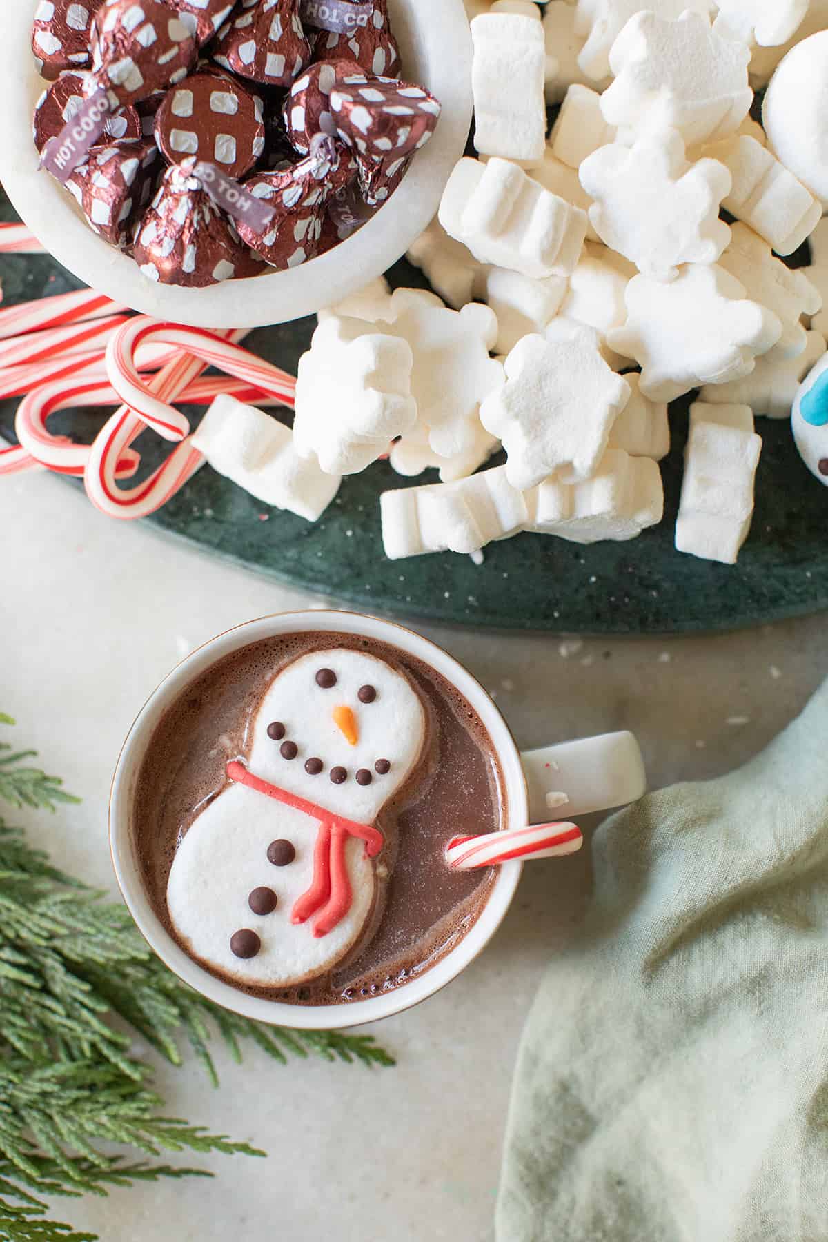 Cup of hot chocolate with a snowman marshmallow on the top.