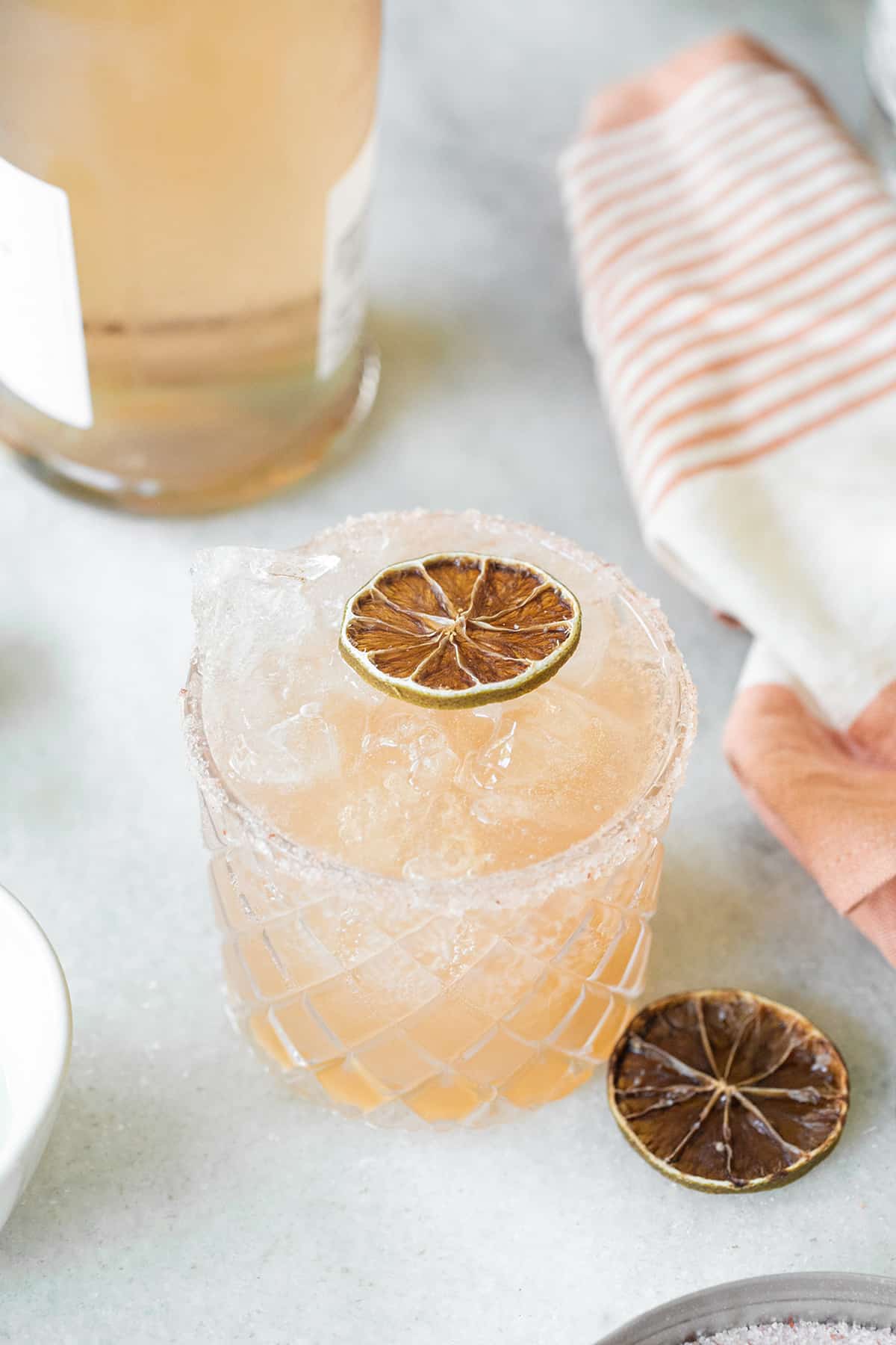 Pink margarita in a glass with a salted rim.