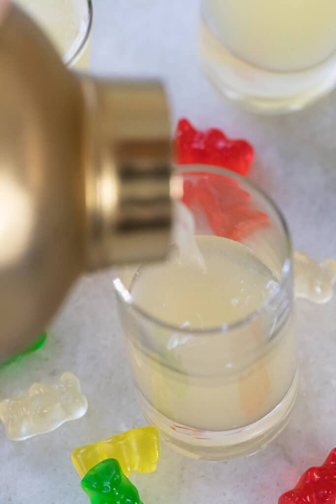 Pouring gummy bear shot from shaker into a shot glass