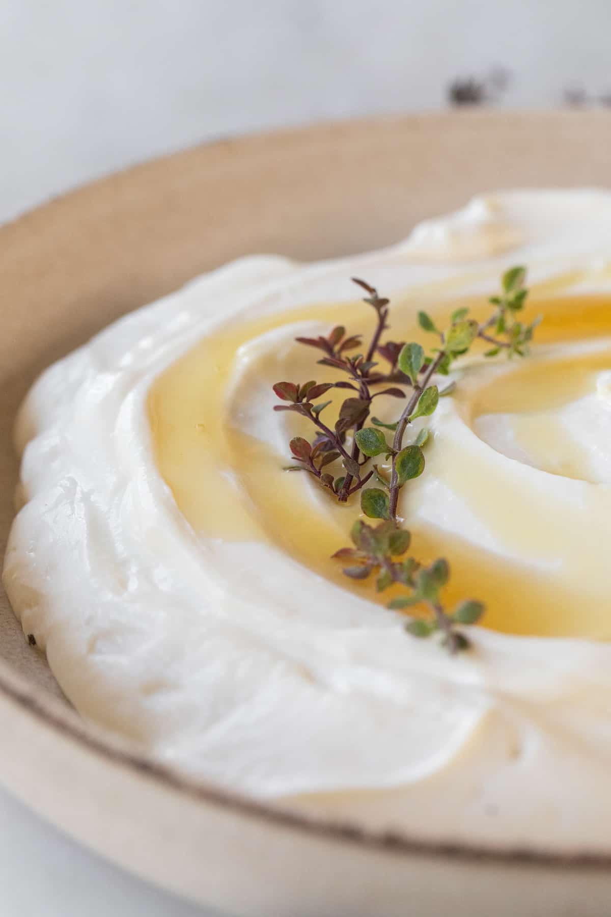 Whipped ricotta in a bowl with honey and thyme.