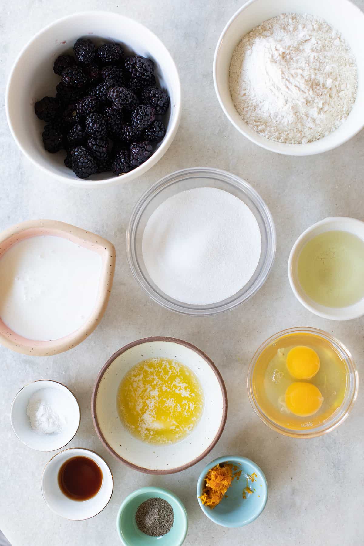 Blackberries, eggs, sugar, buttermilk, orange zest, flour, oil and spices in small bowls.