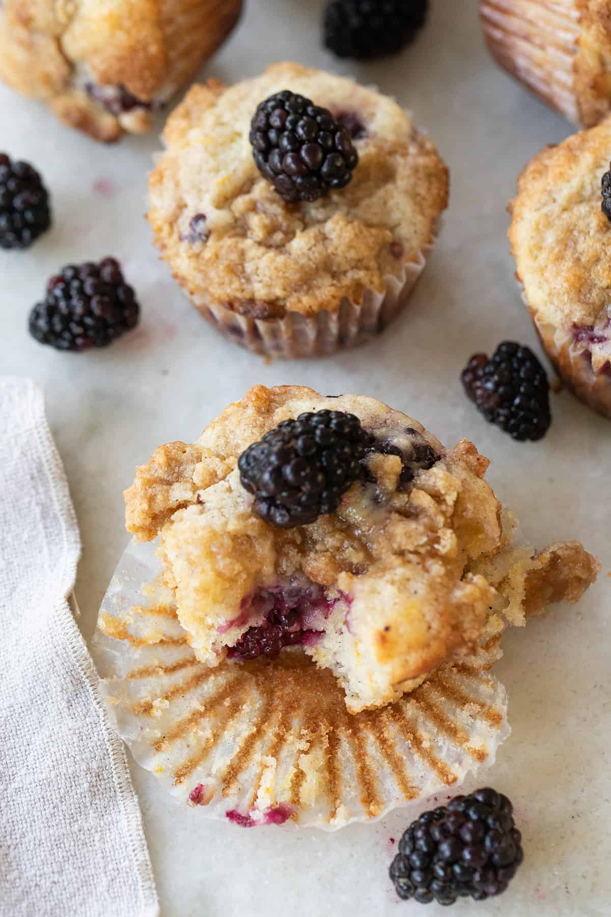 A muffin with blackberries over the top. 