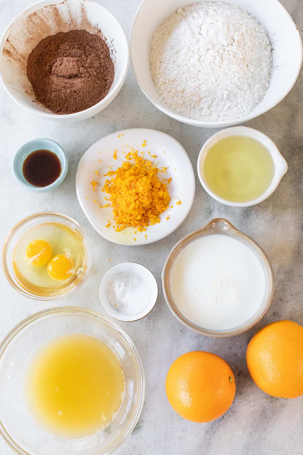 Orange zest, flour, orange juice, eggs, oil, sugar, flour and vanilla in small bowls.