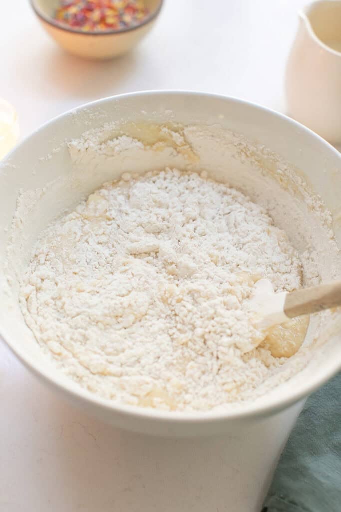 Mixing batter in a bowl to make funfetti cake.