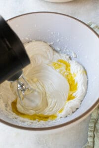 Adding olive oil into the whipped cheese.