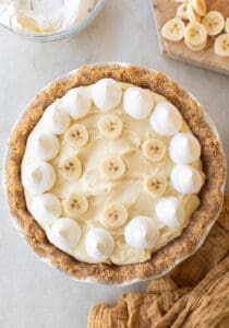 Banana pudding pie with whipped cream and sliced bananas.