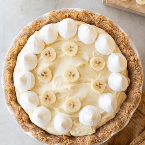 Banana pudding pie with whipped cream and sliced bananas.