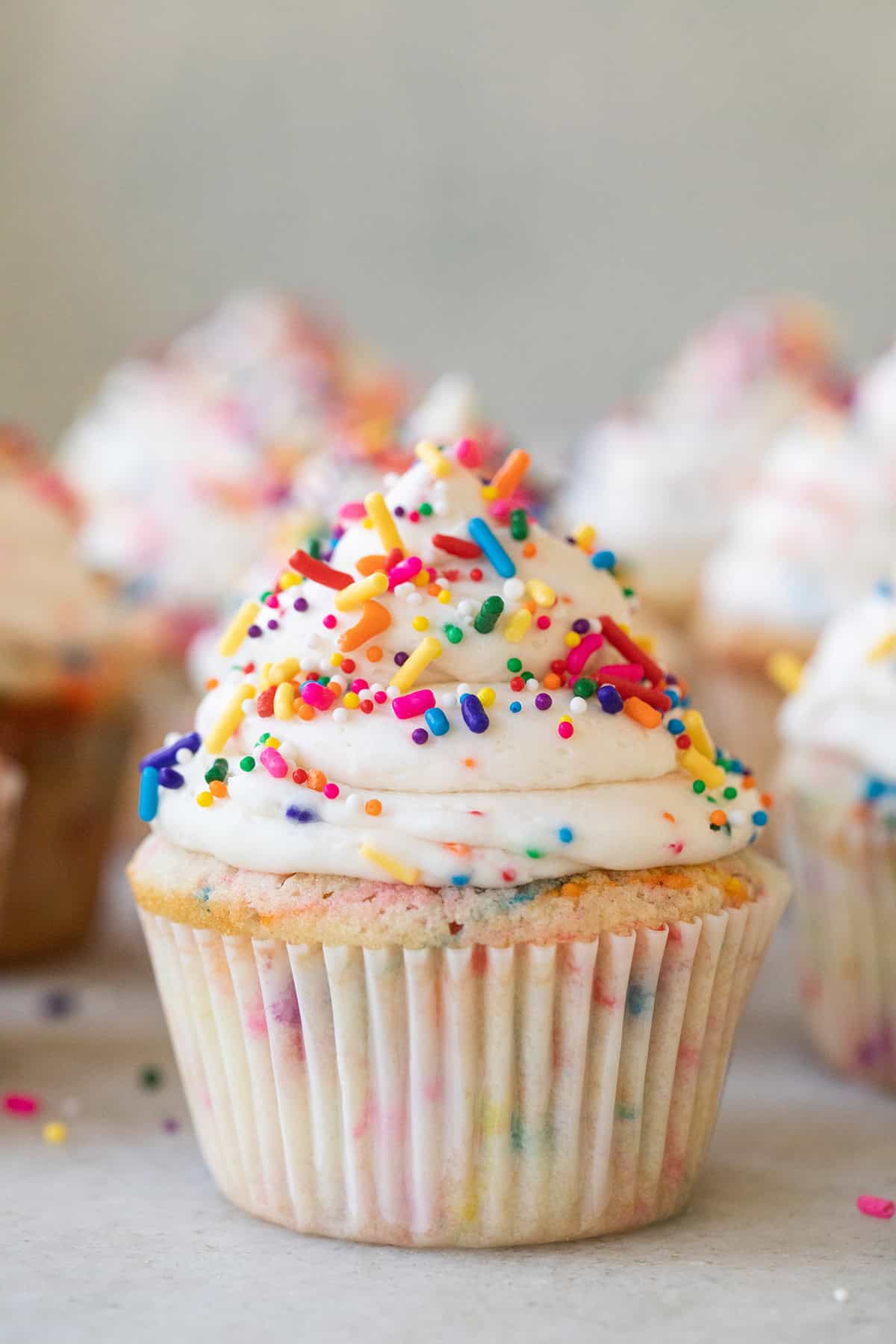 Confetti cupcake with sprinkles and buttercream frosting swirl.