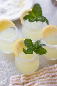 Lemon drop shot with mint leaves and a lemon wedge.