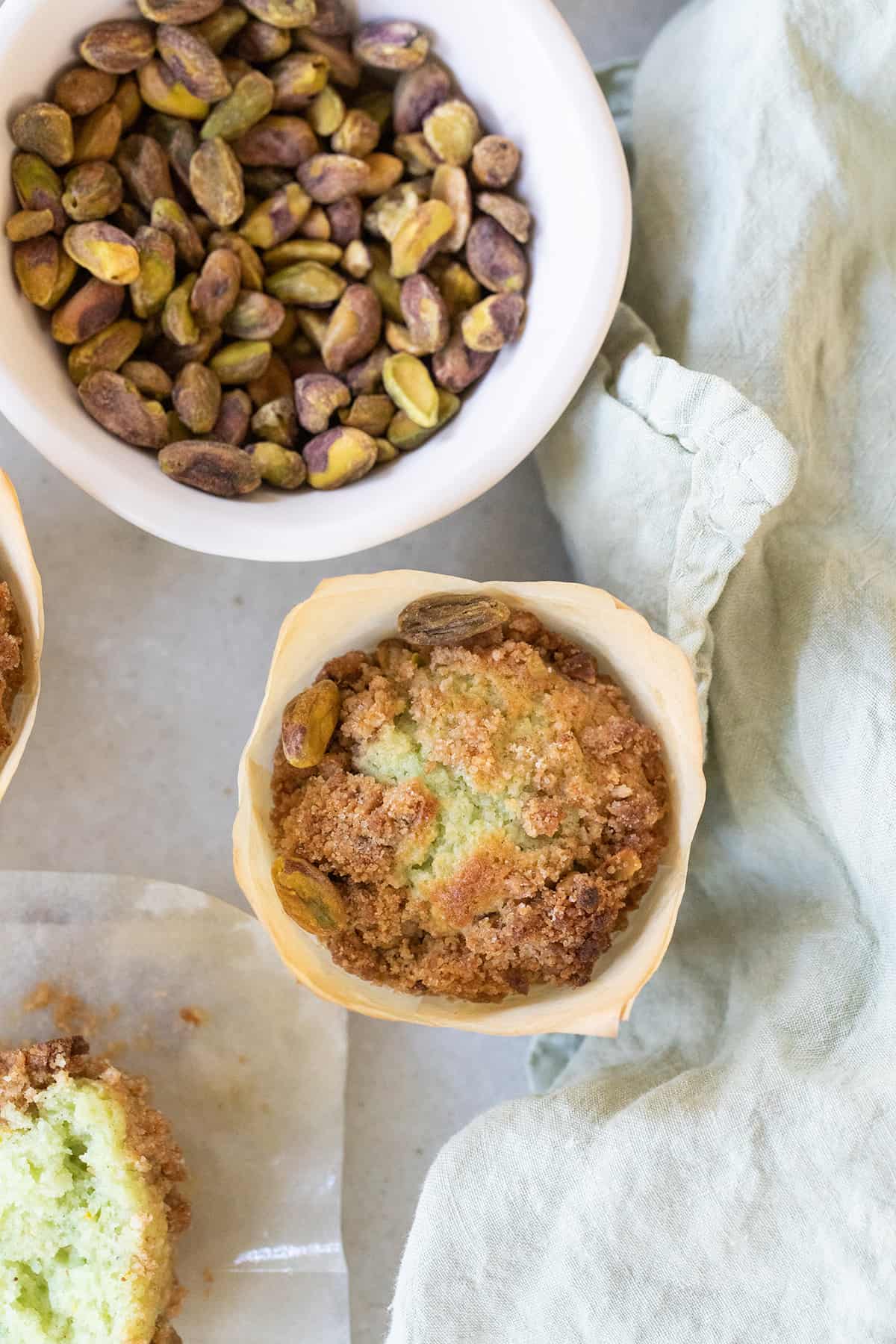 Green pistachio muffin with a crumble top.