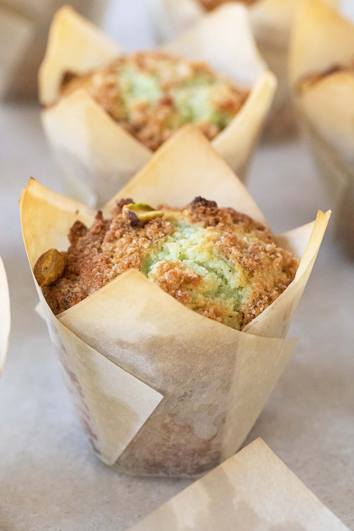 Pistachio muffins in tulip muffin papers.
