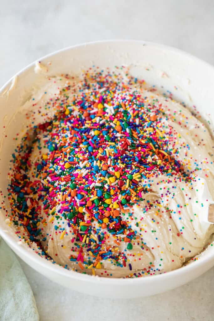 Folding in sprinkles to a vanilla cupcake batter.