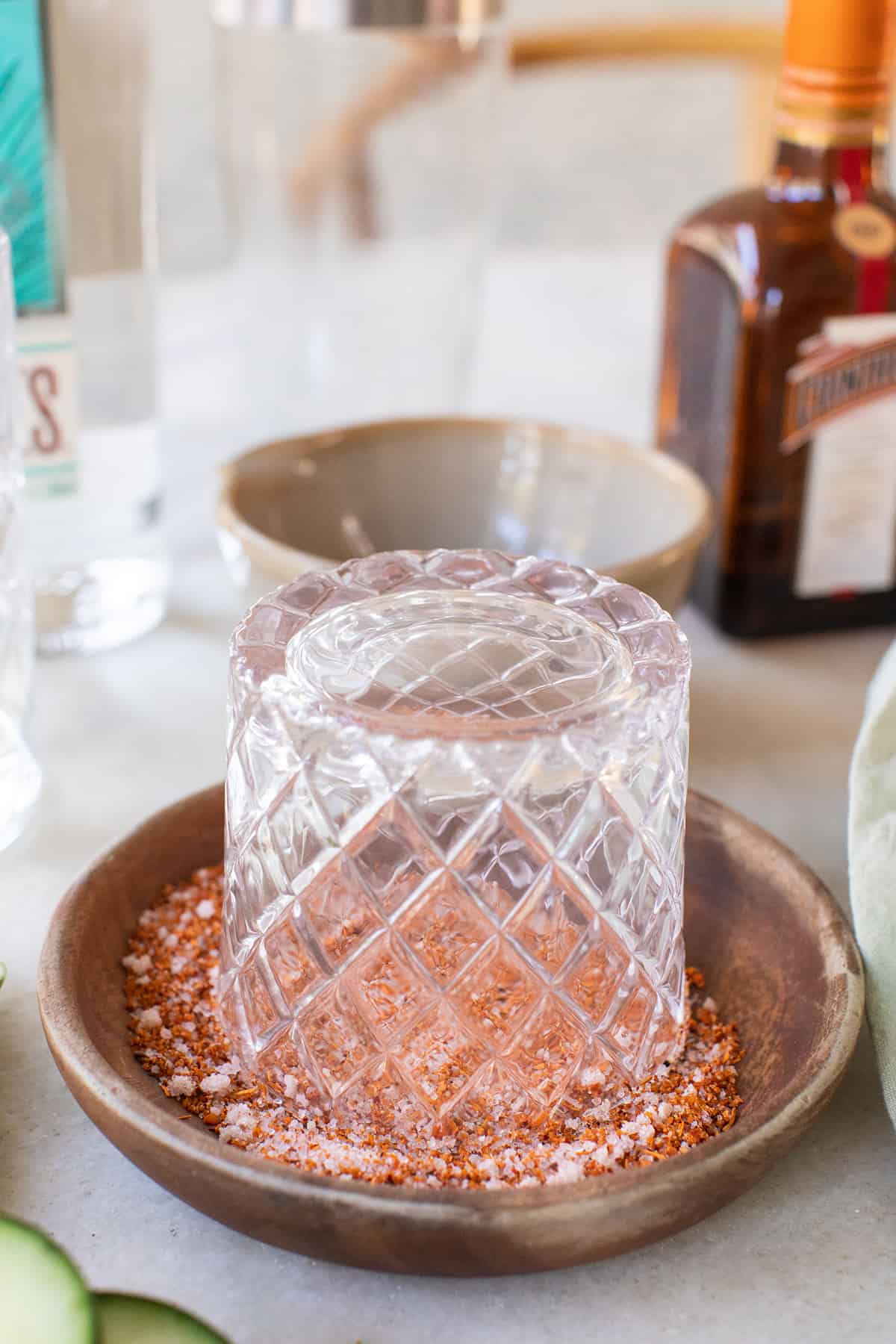 Rimming a cocktail glass with salt and Tajín 