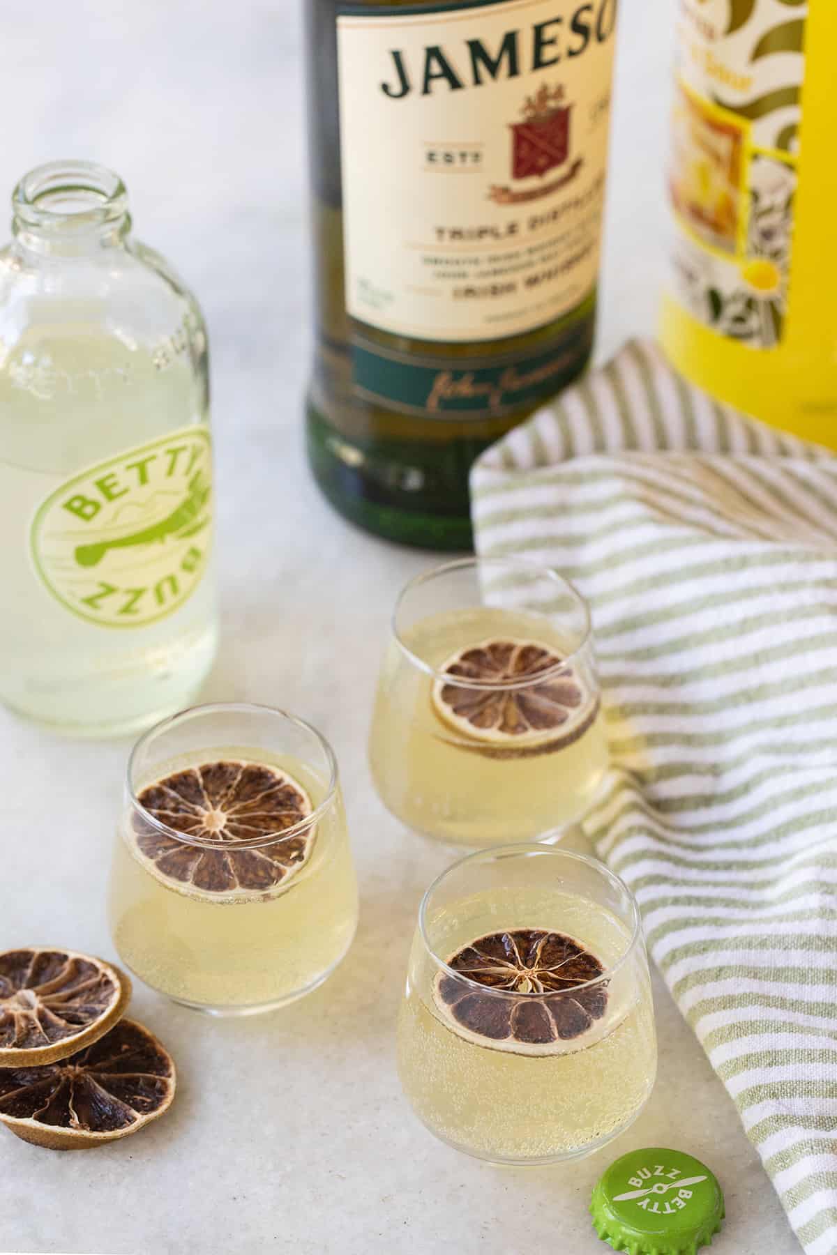 Green tea shots on a marble table with a lime slice. 