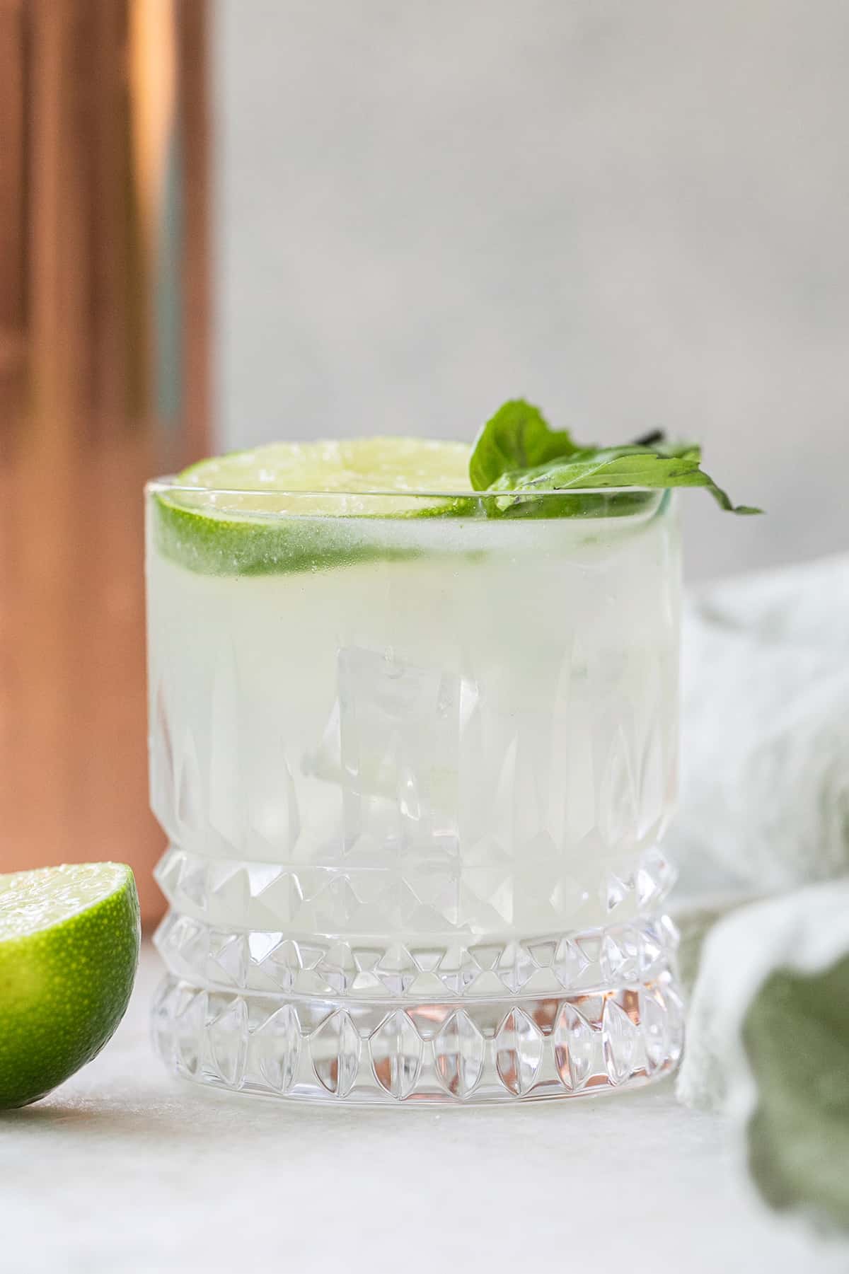 Basil gin smash with lime juice and a basil leaf.