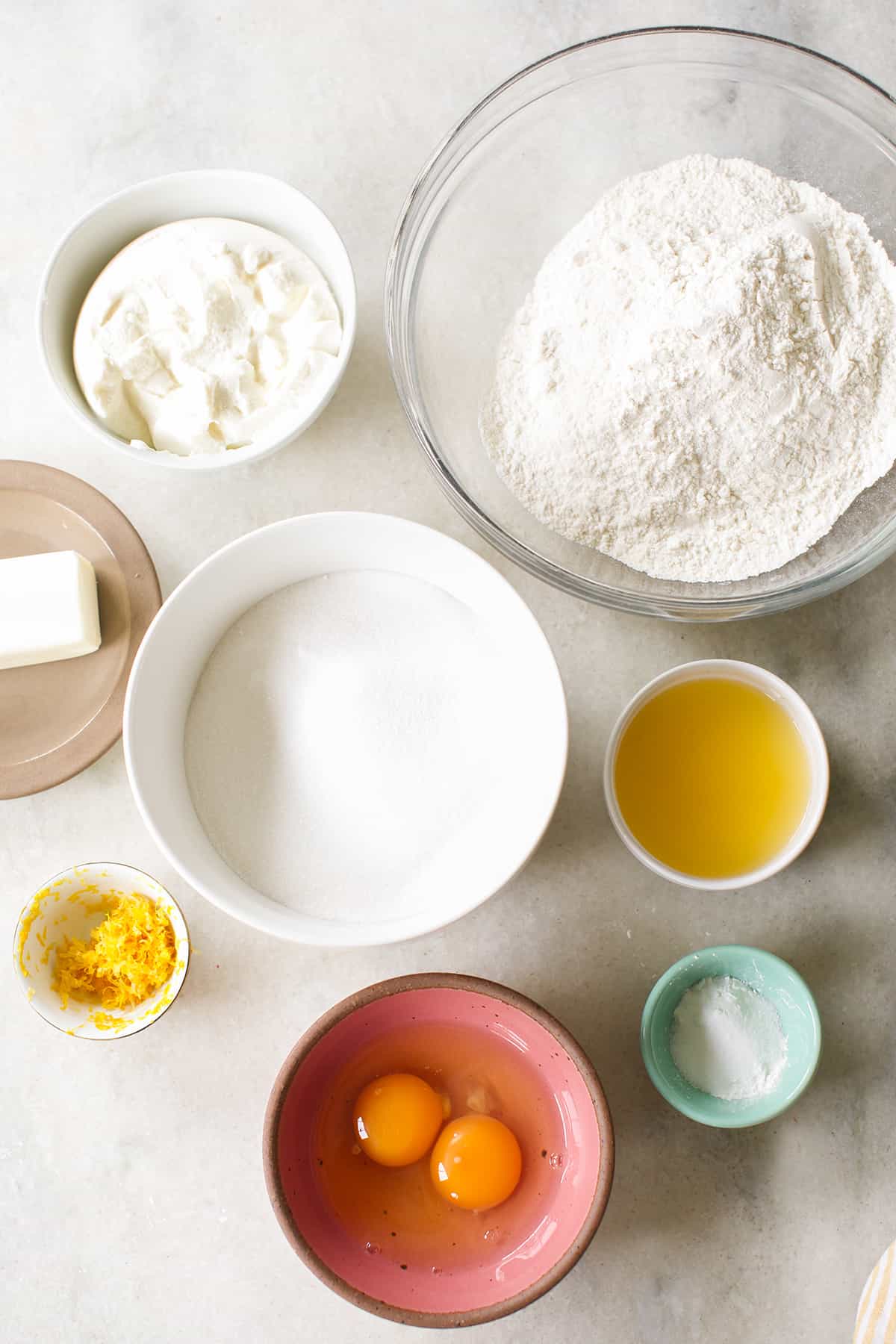 Flour, eggs, lemon juice, butter, baking soda and sugar in bowls.